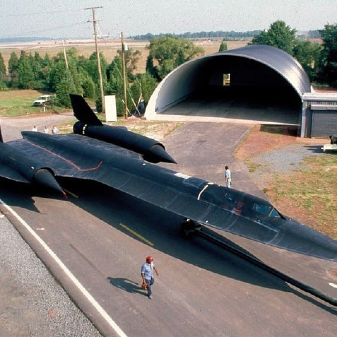 SR-71 Blackbird aircraft on a road with a hangar in the background.